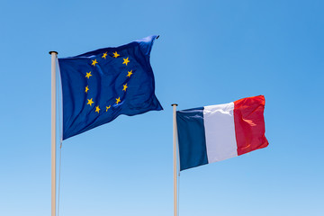 French and European Union (EU) Flag. Waving flags of France and Europe. Blue sky background.