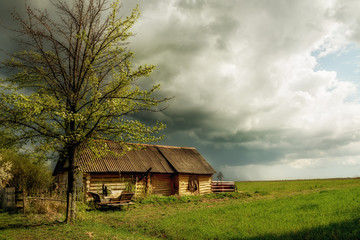 Fototapeta premium An old log cabin and an old cart. Vintage retro view in the countryside. Ukrainian village.