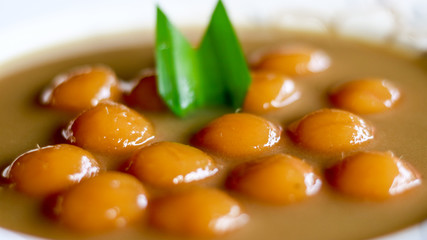 Biji salak on white background. Biji salak is sweet potato dumplings with coconut sauce. Popular dessert in Indonesia or to break the fast.