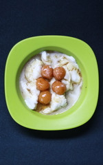 Bubur sum sum on black background. Bubur sum sum is an Indonesian dessert made by cooking rice flour in coconut milk and served with palm sugar syrup.