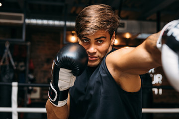 Close up of a male sportsman doing shadow boxing inside a boxing ring