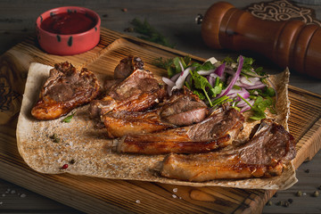 Fried meat in a Caucasian style on a pita with onions and greens. Closeup