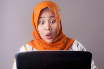 Muslim Businesswoman Working on Laptop Shocked Stunned gesture