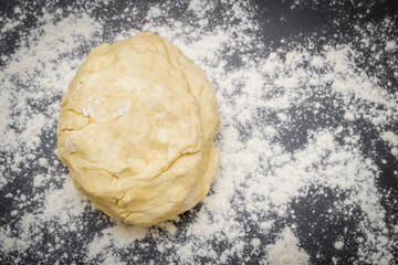 Raw dough is on the table with flour before cooking cottage cheese cookies