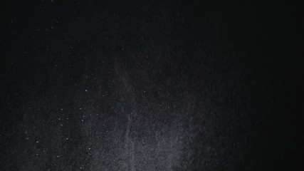 White exploding powder over black background