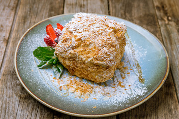 Napoleon dessert on plate on wooden background