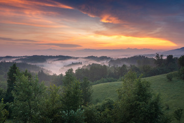 Fototapeta na wymiar Sunset over the Alps on a foggy evening in Tunjice, Upper Carniola, Slovenia