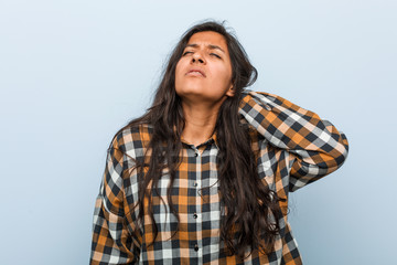 Fototapeta premium Young cool indian woman suffering neck pain due to sedentary lifestyle.