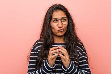 Young intellectual indian woman making up plan in mind, setting up an idea.