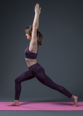 Beautiful sporty fit young woman practices yoga asana.