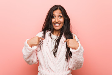 Fototapeta premium Young indian woman wearing pajama surprised pointing at himself, smiling broadly.