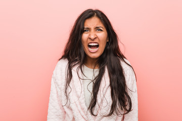 Young indian woman wearing pajama screaming very angry and aggressive.