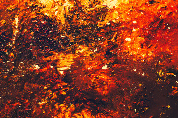 Abstract art texture background. Closeup of amber gemstone design. Red, orange and brown paint mixture splash.