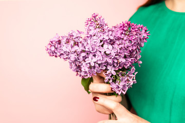 Woman hiding head in bouquet lilac flowers