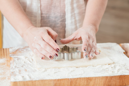 Culinary master class. Woman using star shaped cutter on dough to show how to make cookie. Pastry baking course.