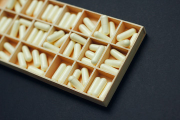 Yellow capsules pills in pillbox. Daily dose of medication. Weekly dosage.