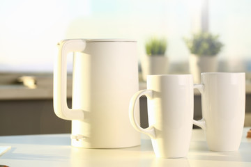 Teapot and two trendy cups are on the table for evening family tea