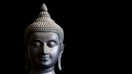 Buddha statue face closeup isolated on black