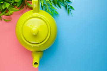 Green classic teapot on a colorful pastel background
