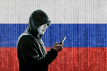 Russian hooded hacker with mask holding smartphone