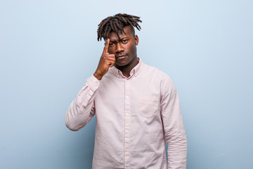 Young business african black man pointing temple with finger, thinking, focused on a task.