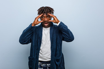 Young african black man wearing pajama keeping eyes opened to find a success opportunity.