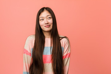 Fototapeta premium Young cool chinese woman dreaming of achieving goals and purposes