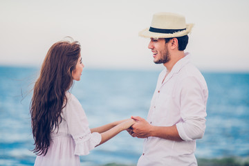 Happy Romantic Couples lover holding hands together walking on the beach