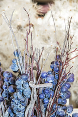 Rustic decorator purple berries and stems against bokeh natural background - vertical