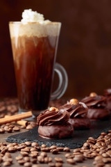  Chocolate dessert with hazelnut and coffee with cream on a wooden table.