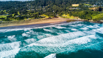 Oceanic surf on a popular beach on sunny day. Muriwai Beach, Auckland, New Zealand