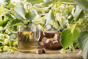 Glass of linden tea with brown sugar .