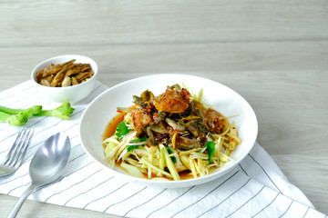 Papaya Salad with Crab. Thai food cuisine menu “Somtum”. It’s tasty, Spicy, Sour and Salty. Famous in Thailand and Lao. Close up Dish with fork on wooden background.