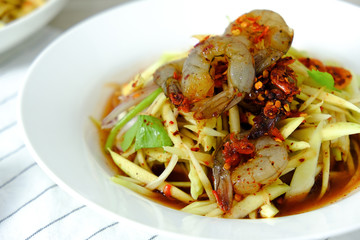 Papaya Salad with Shrimp. Thai food cuisine menu “Somtum”. It’s tasty, Spicy, Sour and Salty. Famous in Thailand and Lao. Close up Dish with fork on wooden background.