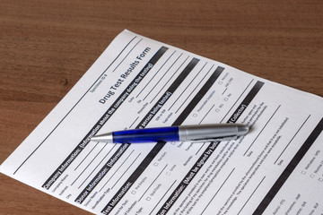 Drug test results form and pen blue color on the table, top view