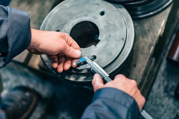 Measuring metal parts with vernier caliper, close-up.