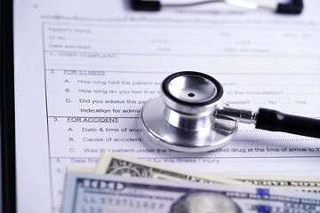 Health insurance accident claim form with stethoscope and US dollar banknotes, Medical concept.    