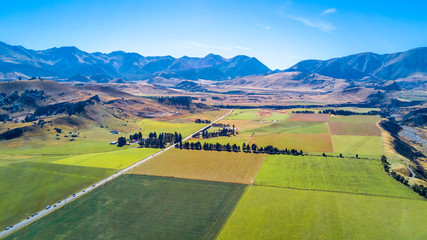 Road running through farmland with mountains on the background. West Coast, South Island, New Zealand © Dmitri