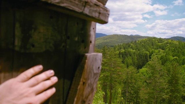 Hand opening secret door to mountain view with medieval castle