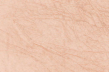 Light brown skin texture, natural or faux leather background. Pinkish leatherette, closeup.
