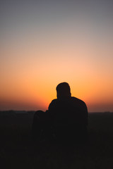 Guy sitting in front of Sunset