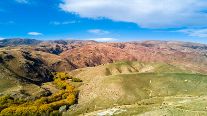 Hill terrain with small rivers and valleys on a sunny day. Otago, South Island, New Zealand