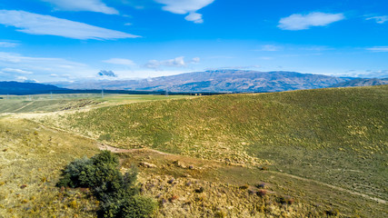 Hill terrain with small rivers and valleys on a sunny day. Otago, South Island, New Zealand
