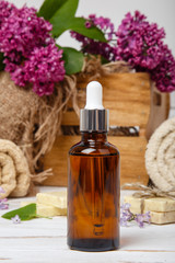 Obraz na płótnie Canvas Natural cosmetics with lilac flowers. Serum, soap and cream. Face care products. Prepare to bath. Spa therapy concept photo. Organic cosmetic on wooden background. Cosmetics for relax and aromatherapy
