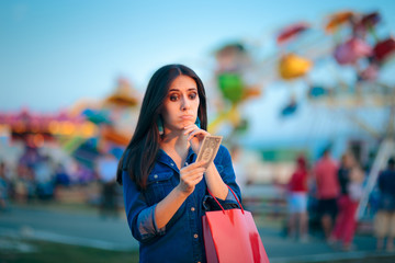 Fototapeta premium Broke Woman Holding one Dollar at Summer Funfair