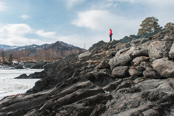 Happy woman relaxing on the top of mountain at beauty sunny spring day, in Altai mountains. Travel vacation concept.