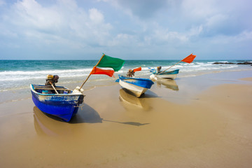 Fishing boats on the beach with cloudy sky