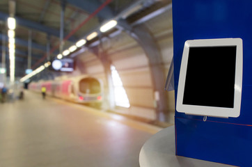 blank screen digital monitor or tablet on counter at subway train station, copy space for text or media content, ticket vending machine, technology, transportation, marketing and advertisement concept