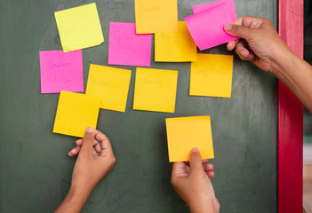 Close up businessman hands holding note sticky for brainstorm ans share idea strategy workshop business.Brainstorming concept