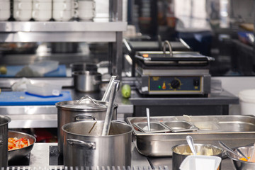 Professional cuisine restaurant. Kitchen utensils, plate with metal pots with lids and scoops. Сoncept violation conditions and shelf life products, food poisoning, sanitary inspection
